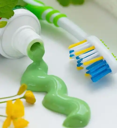 Private label toothpaste tubes with custom branding and packaging samples arranged on a clean white surface next to manufacturing notes
